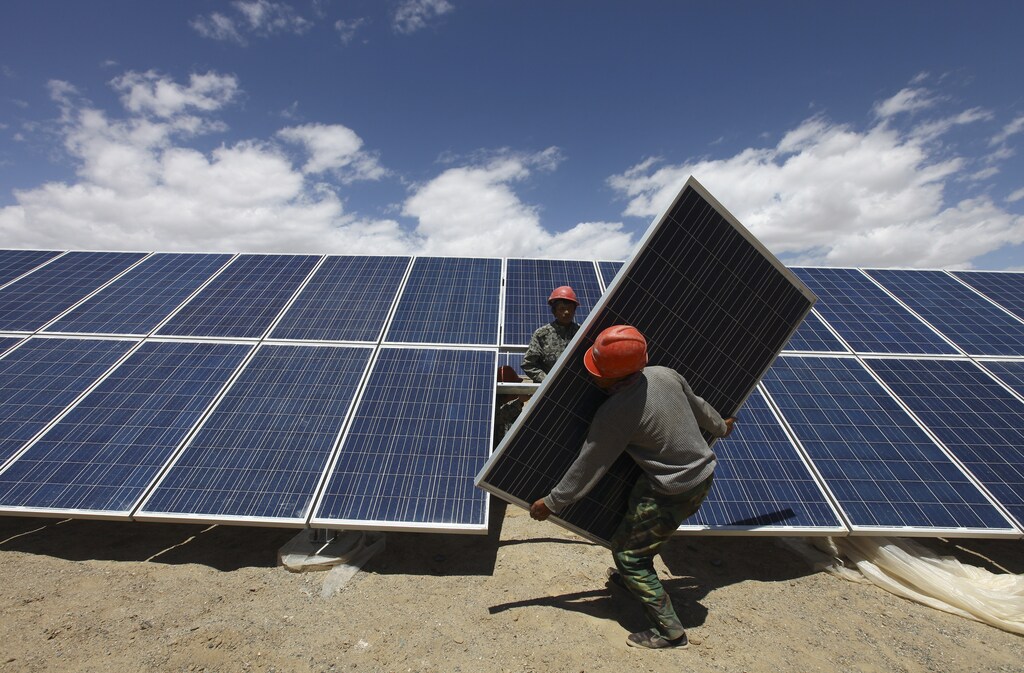 Workers install a solar panel in Jiuquan, Gansu province, July 14, 2013. China aims to more than quadruple solar power generating capacity to 35 gigawatts by 2015 in an apparent bid to ease a massive glut in the domestic solar panel industry. Picture taken July 14, 2013. REUTERS/Stringer (CHINA - Tags: BUSINESS ENERGY) CHINA OUT. NO COMMERCIAL OR EDITORIAL SALES IN CHINA - GM1E97H0X0A01