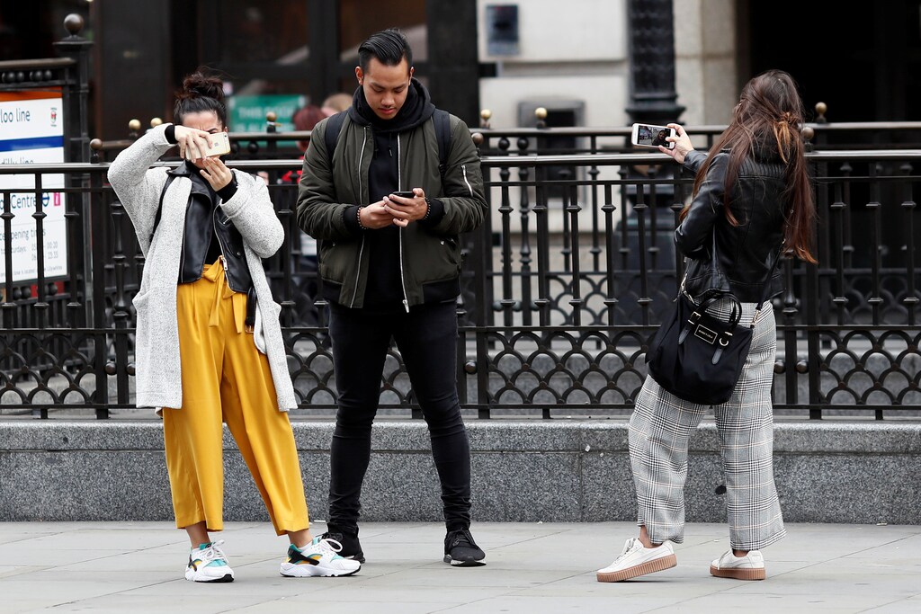 People look at their mobile phones at Piccadilly Circus in London, Britain October 6, 2016. REUTERS/Stefan Wermuth SEARCH "WERMUTH PHONES" FOR THIS STORY. SEARCH "THE WIDER IMAGE" FOR ALL STORIES.? - RC1F7BC92590