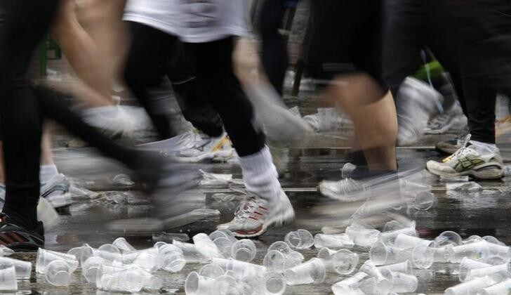 Runners run over plastic cups near a refreshment stop during 28th Berlin half-marathon in Berlin April 6, 2008. More than 24,000 participants are expected to take part of this half-marathon event in the German capital. REUTERS/Fabrizio Bensch (GERMANY)