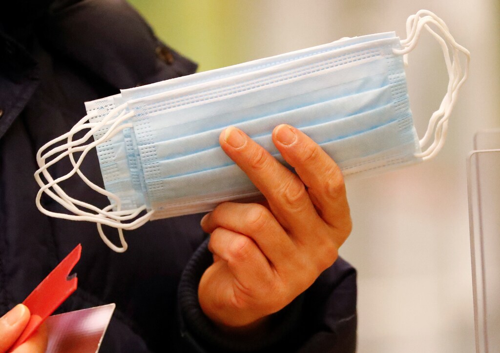 A person holds disposable face masks, that were given for free to socially needy people by the Wedding district city hall, during an extended lockdown due to the coronavirus disease (COVID-19) pandemic, in Berlin, Germany, January 26, 2021. REUTERS/Fabrizio Bensch - RC2OFL9YZ8SJ