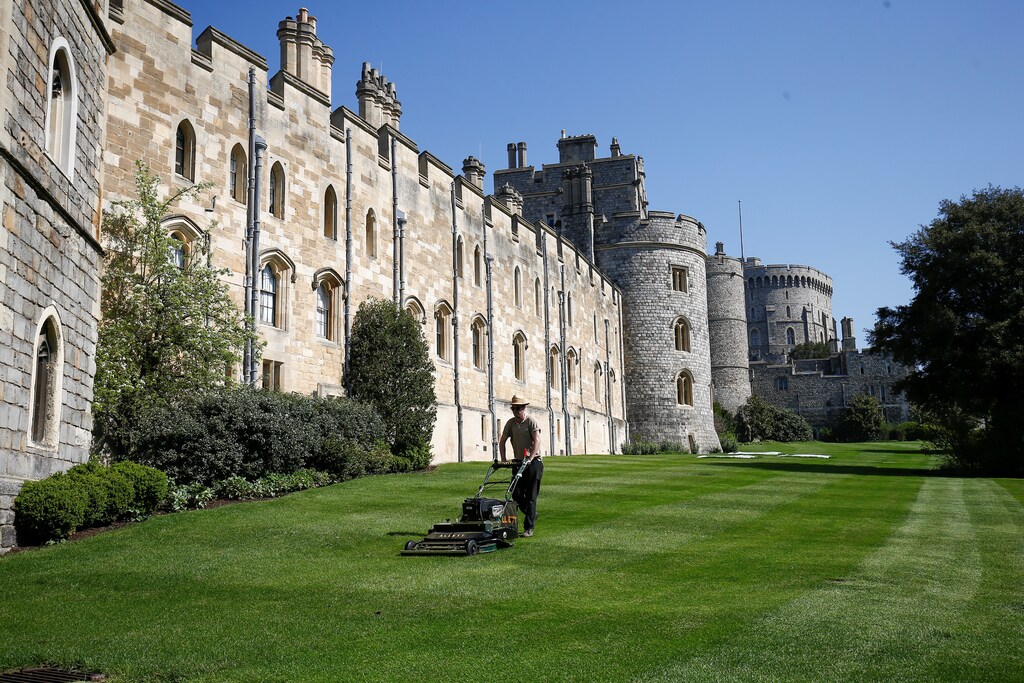 A groundsman mows the lawn outside Windsor Castle in the sun, in Windsor, Britain. April 20, 2018. REUTERS/Henry Nicholls - RC173B9F3BF0
