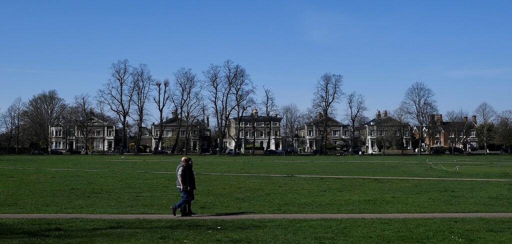People walk across Richmond Green public space in Richmond South West London as the spread of the coronavirus disease (COVID-19) continues, in London, Britain, March 24, 2020. REUTERS/Toby Melville - RC2EQF9EX9Y4