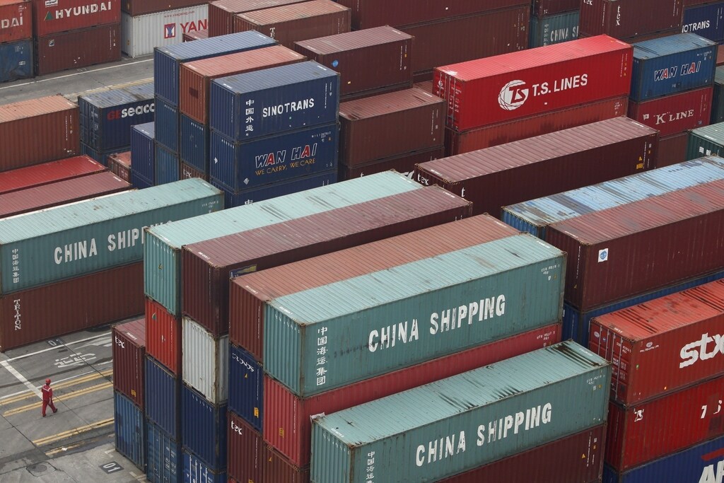 A worker walks in a shipping container area at the Port of Shanghai April 10, 2012. China returned to an export-led trade surplus of $5.35 billion in March, heralding the prospect that a rebound in the global economy is lifting overseas orders just in time to compensate for a slowdown in domestic demand. REUTERS/Aly Song (CHINA - Tags: BUSINESS TRANSPORT) - RTR30JOK