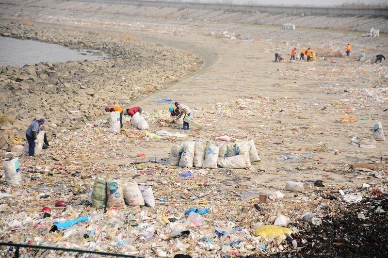 Workers clear garbage at the bank of Yangtze River in Taicang, Jiangsu province, China, December 23, 2016. REUTERS/Stringer ATTENTION EDITORS - THIS IMAGE WAS PROVIDED BY A THIRD PARTY. EDITORIAL USE ONLY. CHINA OUT. NO COMMERCIAL OR EDITORIAL SALES IN CHINA. - RC1EC841D900