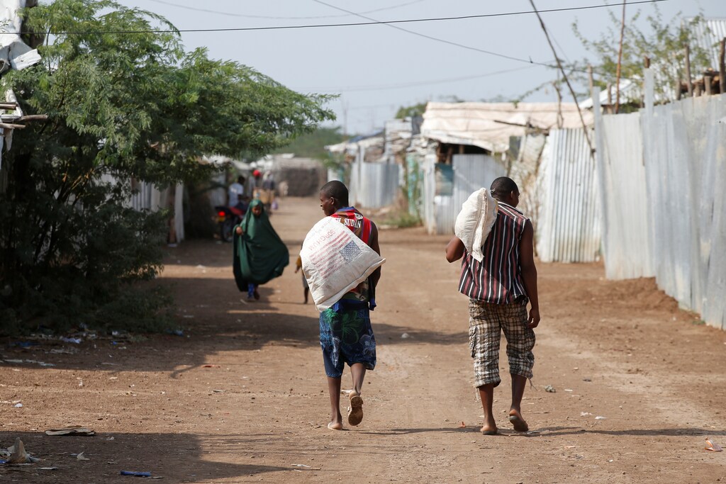 Men carry bags of food aid at the Kakuma refugee camp in northern Kenya, March 6, 2018. Picture taken March 6, 2018. REUTERS/Baz Ratner - RC1C03C84960