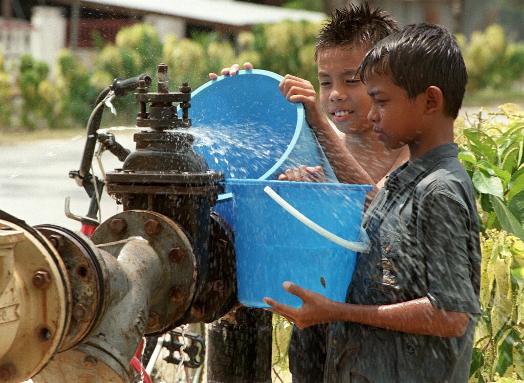 Two boys collect water from a leaking pipe in Kuala Lumpur April 2. Malaysia has started rationing water in parts of the capital city due to a severe drought which caused reservoir water levels to drop. Authorities have announced that the capital city has a shortage of 105 million litres per day which was aggravated by the prolonged drought which started late last year.MALAYSIA - RP1DRIFEMBAA
