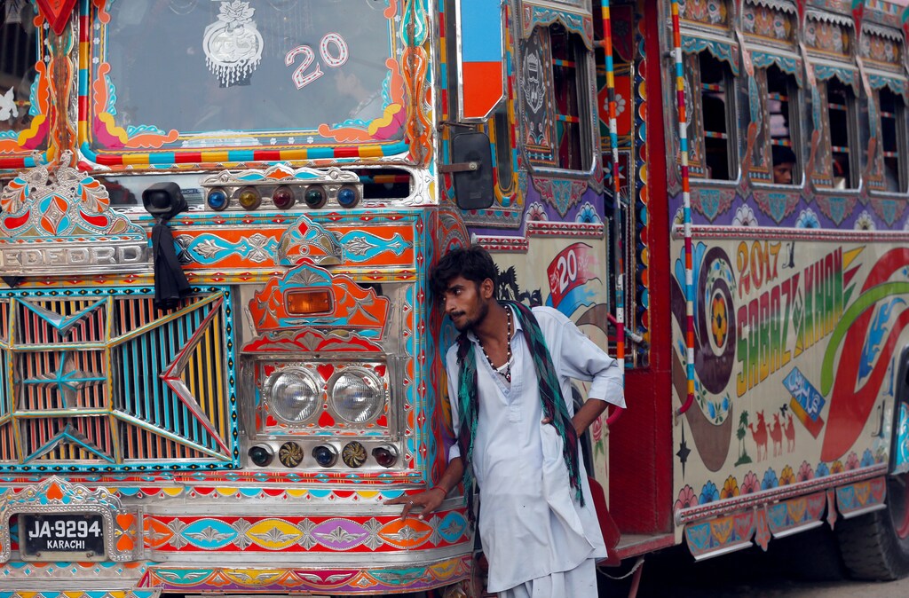 A conductor leans on a bus as he waits for passengers at a bus stop in Karachi, Pakistan June 14, 2017. REUTERS/Akhtar Soomro - RC1AC4817190