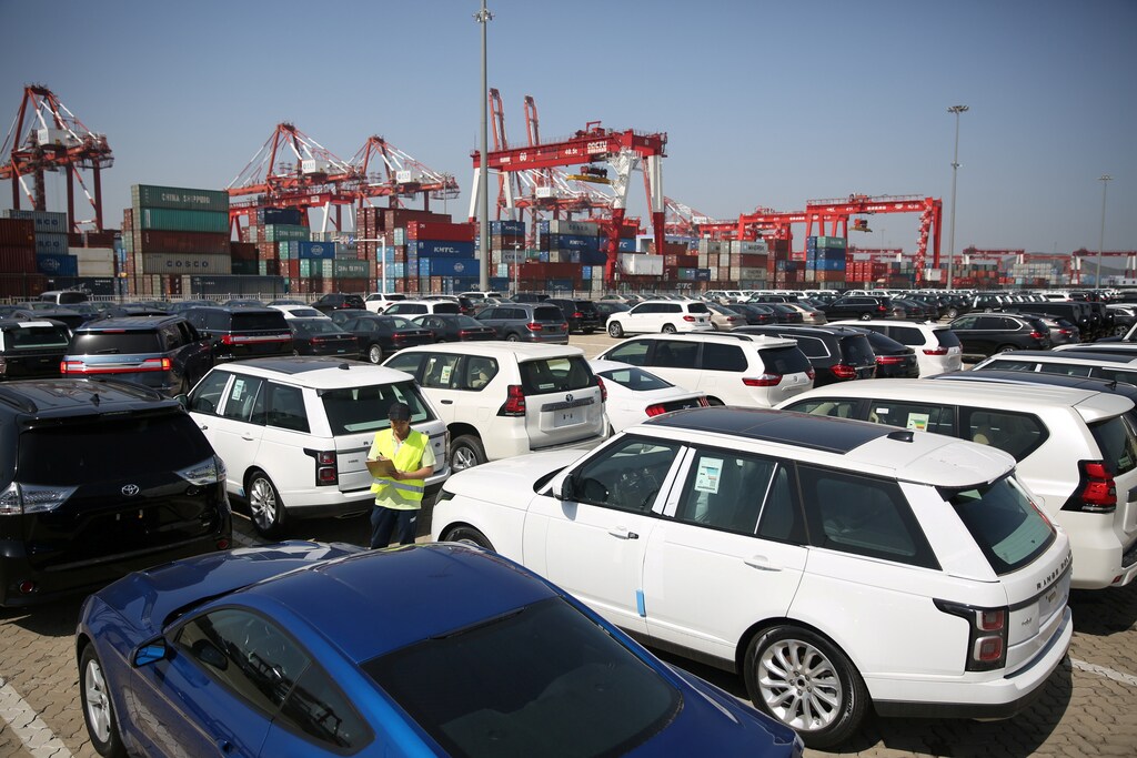 A worker inspects imported cars at a port in Qingdao, China