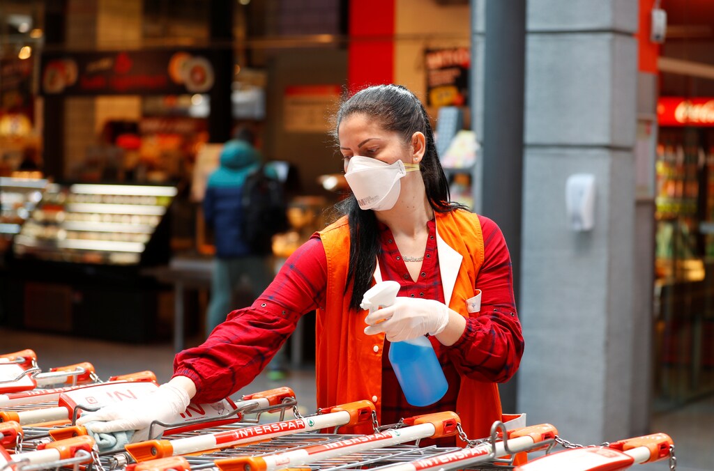 Un empleado de los supermercados Spar con una máscara facial protectora desinfecta los carritos de la compra durante el brote de la enfermedad coronavirus (COVID-19) en Viena, Austria, el 1 de abril de 2020.