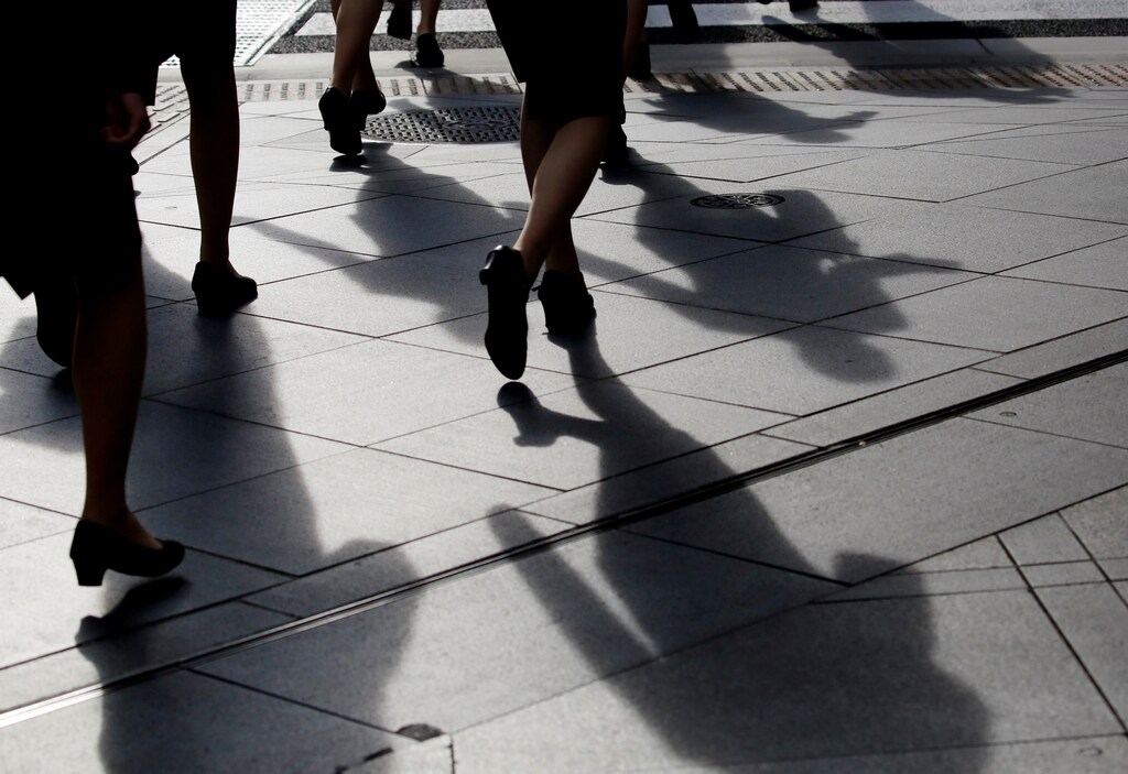 Female office workers wearing high heels and clothes of the same colour walk at a business district in Tokyo, Japan, June 4, 2019. REUTERS/Kim Kyung-Hoon - RC13C7A39000