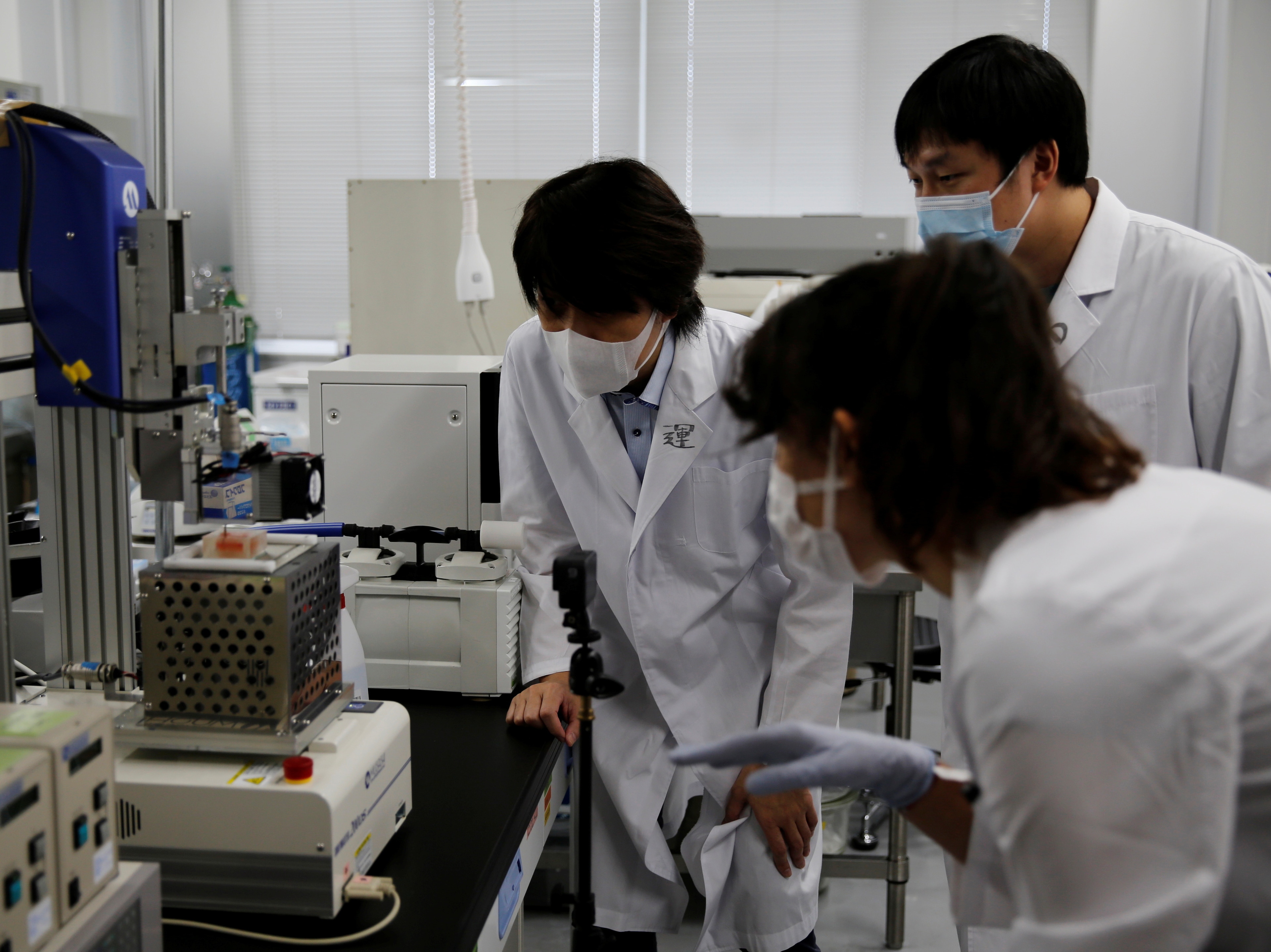 Osaka University Professor Michiya Matsusaki and fellow researchers look at a 3-D printer at a lab at the university in Suita, Osaka Prefecture, Japan October 5, 2021. Picture taken on October 5, 2021. REUTERS/Akira Tomoshige