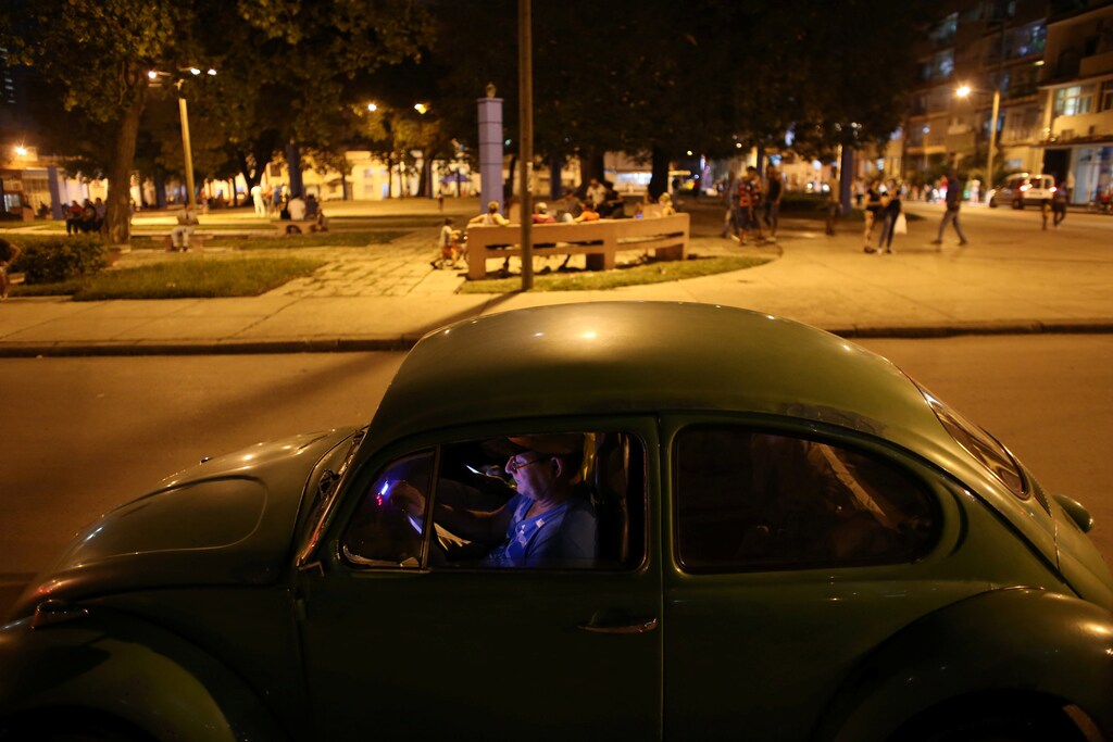 Men use mobile phones to connect to the internet from inside a car at a hotspot in downtown Havana, Cuba, December 12, 2016. REUTERS/Alexandre Meneghini - RTX2UQOH