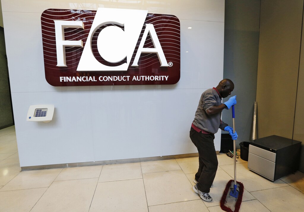 A maintenance worker cleans the entrance area of the headquarters of the new Financial Conduct Authority (FCA) in the Canary Wharf business district of London April 1, 2013. The Financial Services Authority (FSA) has been scrapped from April 1 amid reforms to fix a supervisory system criticised for failing to spot the financial crisis coming, forcing Britain to bail out banks. Two new bodies will replace it - the FCA and the Prudential Regulation Authority. REUTERS/Chris Helgren (BRITAIN - Tags: BUSINESS POLITICS) - RTXY4O9