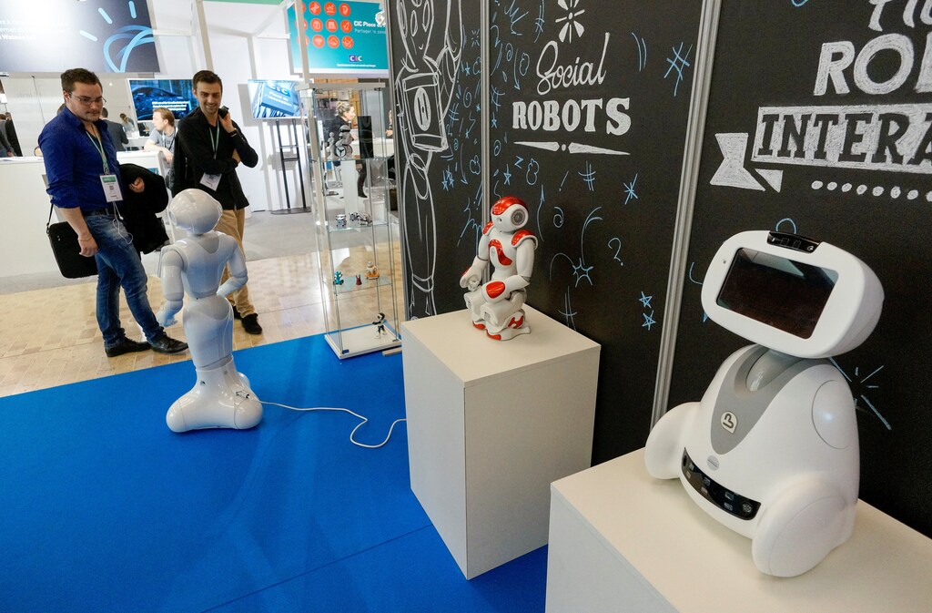 Visitors look at SoftBank humanoid robots named Pepper (L) and Nao (C), and Blue Frog Robotics robot named Buddy (R) at the SIdO, the Connected Business trade show, in Lyon, France, April 6, 2017. REUTERS/Robert Pratta - RTX34EVX