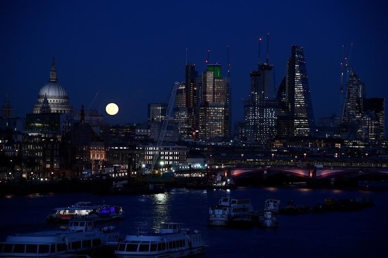 A full moon rises behind The City of London, Britain, January 31, 2018.
