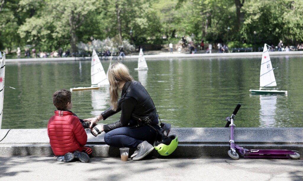 A woman and a child look at miniature sailboats on Mother's Day in Central Park, New York City, U.S., May 14, 2017.