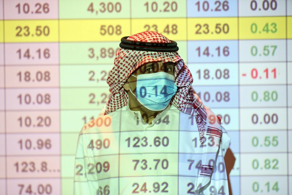 A Saudi trader wears a mask as he monitors stock information at the Saudi stock market in Riyadh, Saudi Arabia August 25, 2020. REUTERS/Ahmed Yosri TPX IMAGES OF THE DAY - RC2ZKI9ZVQ2W