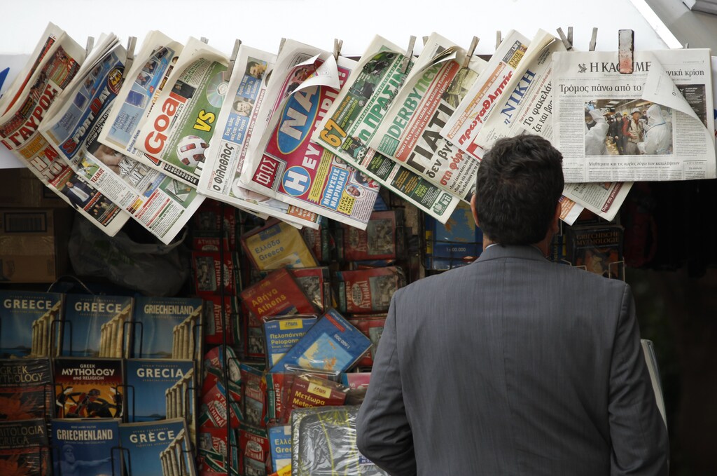A man reads newspapers at a kiosk in central Athens March 16, 2011. Greek journalists unions hold a 24-hour nationwide strike on Thursday against austerity measures. REUTERS/Yiorgos Karahalis (GREECE - Tags: EMPLOYMENT BUSINESS POLITICS) - GM1E73G1SPC01