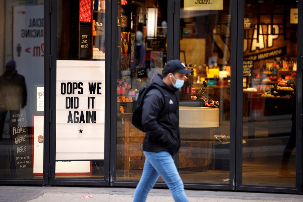 A man wearing a face mask walks past a closed store on the first day of a newly imposed lockdown, amid the outbreak of the coronavirus disease (COVID-19), in London, Britain, November 5, 2020. REUTERS/John Sibley - RC20XJ9D0NX9