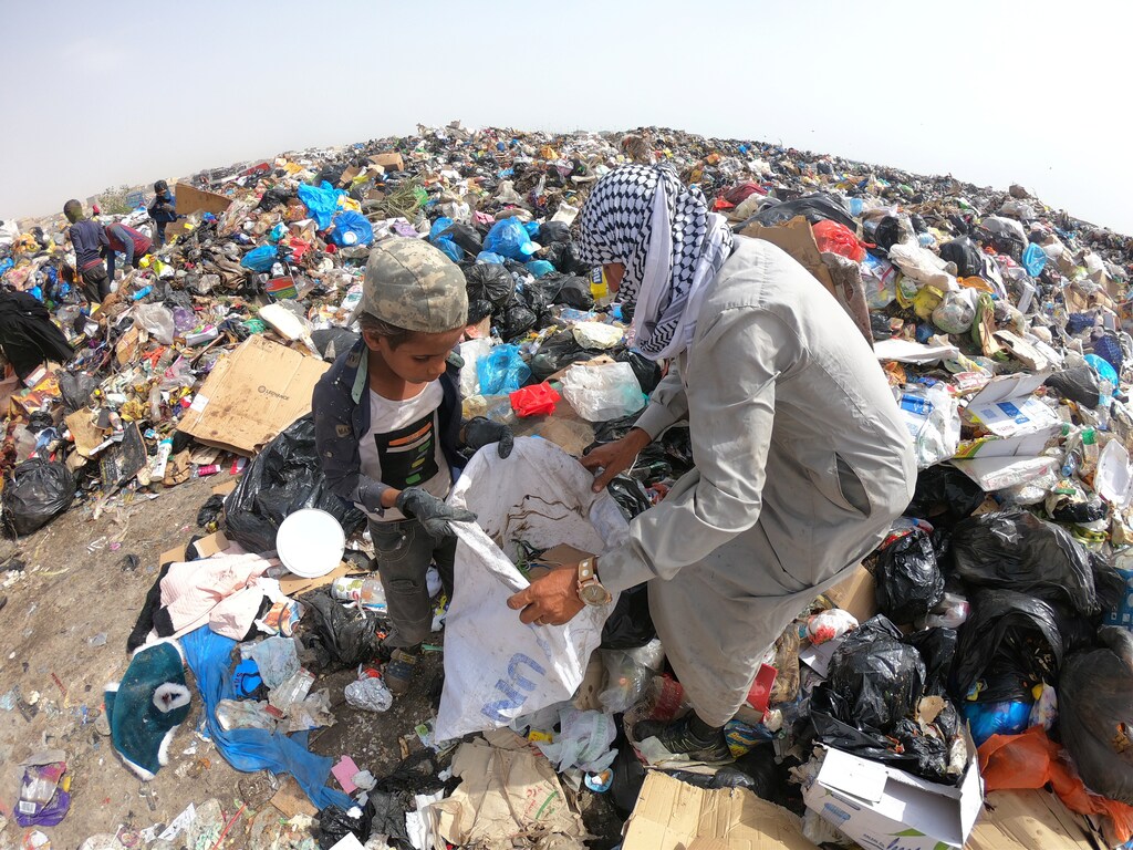 Iraqi people collect recyclable garbage at a dump, amidst concerns about the spread of the coronavirus disease (COVID-19), in Basra, Iraq May 6, 2020. Picture taken May 6, 2020. REUTERS/Mohammed Aty - RC29MG9DERFZ