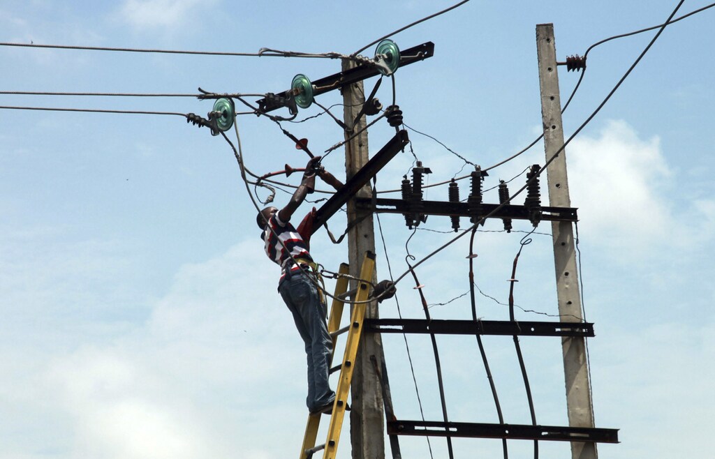 A power official works on an electric pole along a street in Nigeria's commercial capital Lagos October 3, 2012.REUTERS/Akintunde Akinleye(NIGERIA - Tags: ENERGY SOCIETY) - RTR38QYK