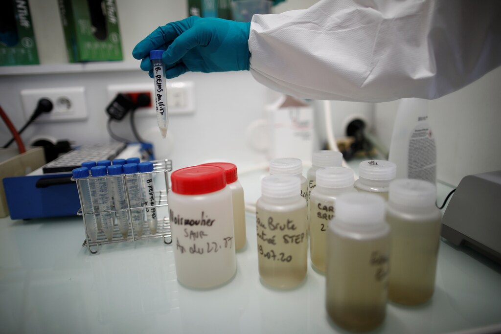 A water quality scientist holds a water sample at the Eau de Paris research and analysis laboratories in Ivry-sur-Seine, near Paris, France, July 22, 2020. Scientists study the Paris waste water to detect the concentration of COVID-19 traces as France remains vigilant against the spread of the coronavirus disease. Picture taken July 22, 2020. REUTERS/Benoit Tessier - RC2ZYH9PJCYY
