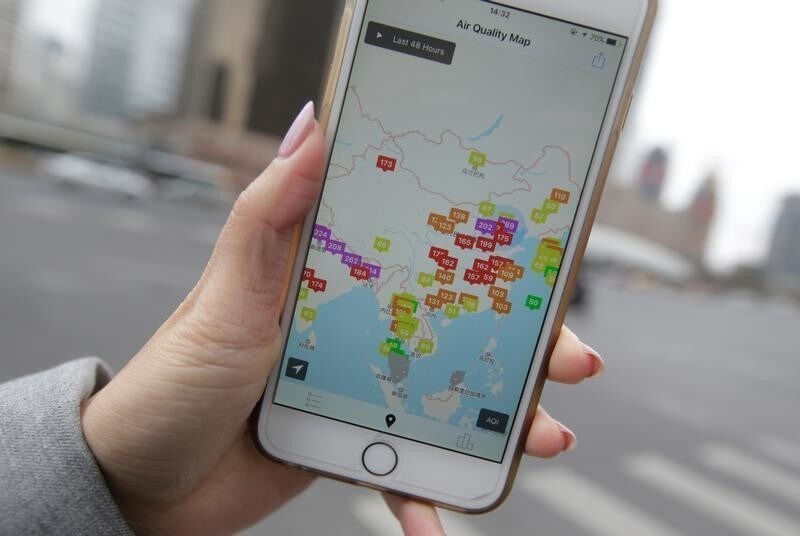 A woman shows a mobile phone app, Air Matters, in this picture illustration taken in China, February 16, 2017. REUTERS/Jason Lee/Illustration - RC1CD7282410