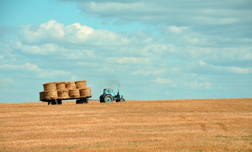 Tractor collecting straw bales from a field