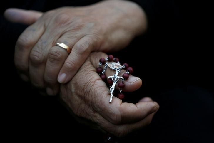 An Iraqi Christian woman holds a cross during a prayer session inside the Syriac Orthodox Church of Mart Shmoni during the Good Friday prayers in Erbil, Iraq, April 14, 2017. REUTERS/Muhammad Hamed TPX IMAGES OF THE DAY