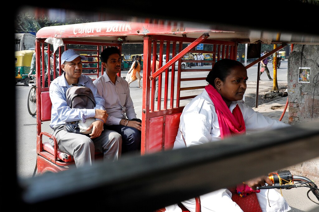 Binota Gayen, 45, rides an electric rickshaw carrying passengers in New Delhi, India, October 5, 2018