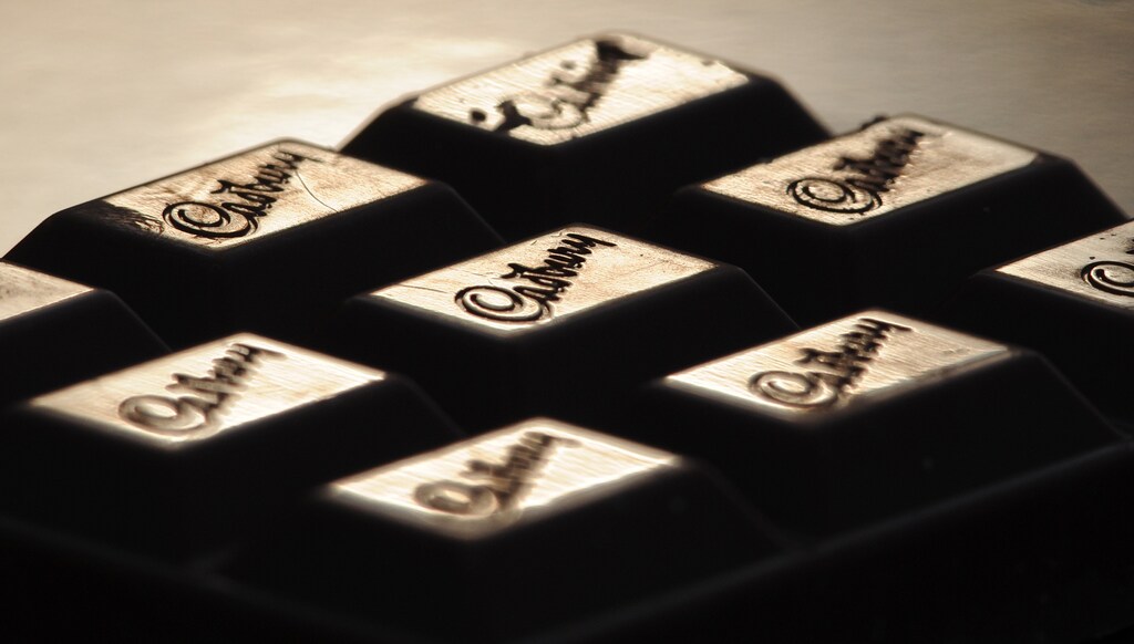 The Cadburys logo is seen on a bar of chocolate December 14, 2009. Cadbury teased shareholders with the prospect of rival bids and promised bigger dividends and stronger growth as it again knocked back a 10 billion pound ($16.2 billion) offer from Kraft Foods, on Monday. REUTERS/Toby Melville (BRITAIN - Tags: BUSINESS EMPLOYMENT) - RTXRUIG