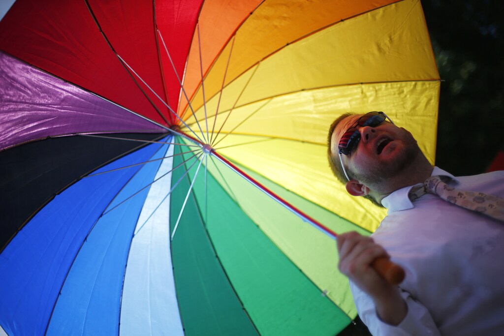 Members of the London Gay Men's Choir perform in front of the Houses of Parliament in central London July 15, 2013
