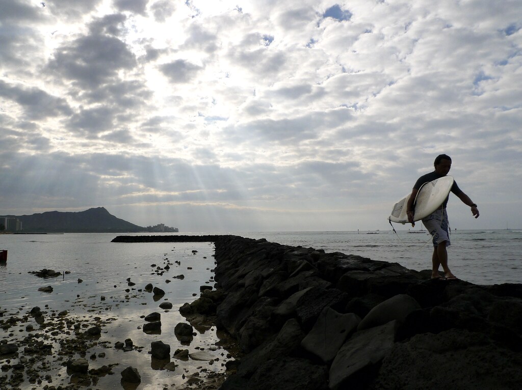 Surfer walks with his surfboard on Waikiki Beach in Honolulu, Hawaii December 30, 2009. REUTERS/Larry Downing (UNITED STATES - Tags: SOCIETY IMAGES OF THE DAY) - GM1E5CV09E401