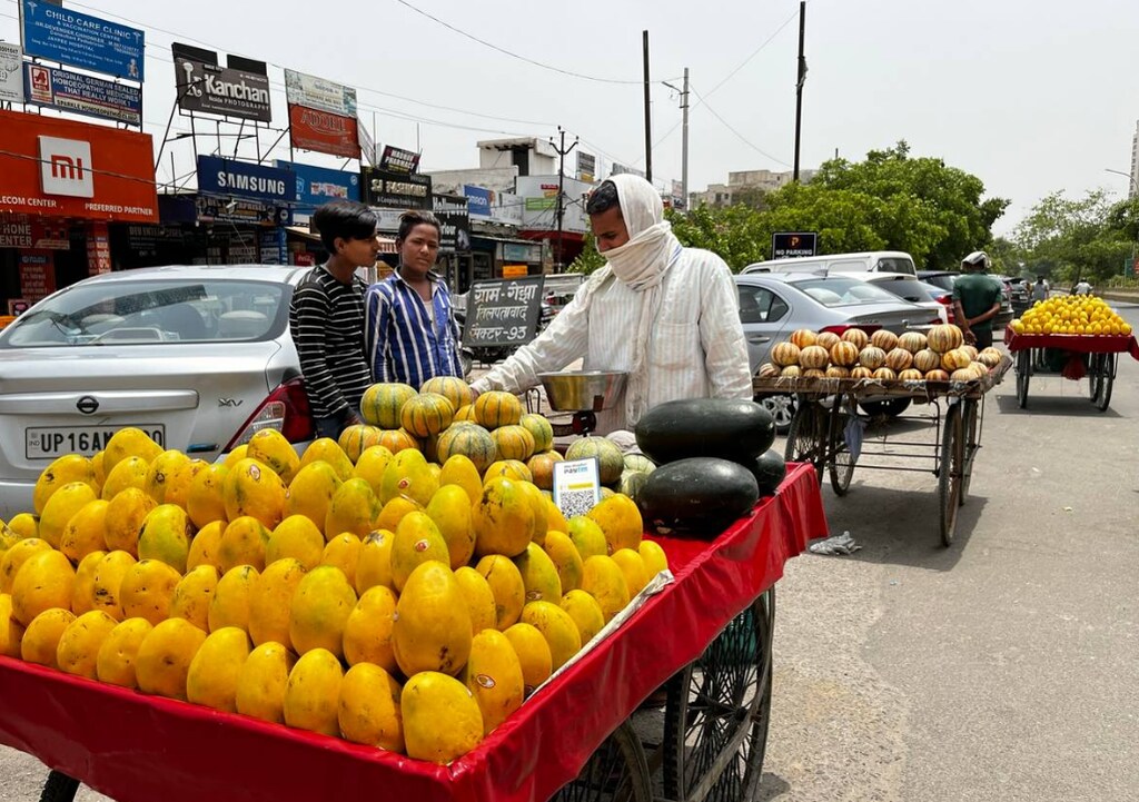 A fruit seller waits for customers during an intense heatwave in Noida, India
