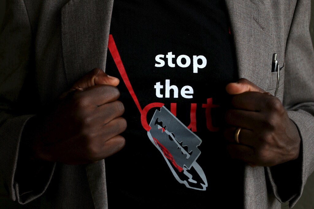 A man shows the logo of a T-shirt that reads "Stop the Cut" referring to Female Genital Mutilation (FGM) during a social event advocating against harmful practices such as FGM at the Imbirikani Girls High School in Imbirikani, Kenya, April 21, 2016. REUTERS/Siegfried Modola - GF10000390963