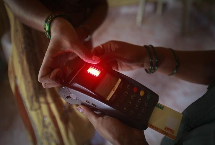 Karuna Prakash Mukudum, a coordinator working for Financial Information Network and Operations Ltd (FINO), processes a smart card as she collects money from a woman in Wavanje village of Raigad district, about 50 km from Mumbai July 2, 2013. Picture taken July 2. To match story INDIA-BANK/ REUTERS/Danish Siddiqui (INDIA - Tags: BUSINESS)
