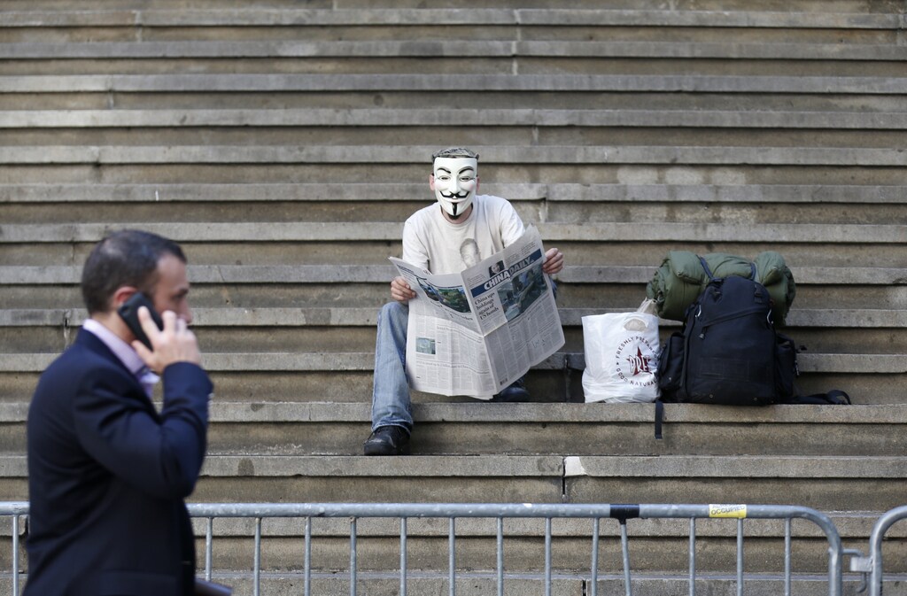 A lone Occupy Wall Street protester sits in front of Federal Hall, across the street from the New York Stock Exchange, in New York June 8, 2012. More than eight months after Occupy Wall Street stormed the global stage, decrying economic inequality and coining the phrase "We are the 99 percent," the movement appears to be losing steam. Donations to the flagship New York chapter have slowed to a trickle. Polls show that public support is rapidly waning. Media attention has dropped precipitously.