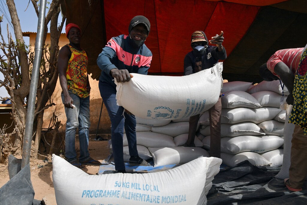 Workers carry the aid provided by the World Food Programme (WFP) for distribution in Pissila, Burkina Faso January 24, 2020. Picture taken January 24, 2020. REUTERS/Anne Mimault - RC21PE9DV74I