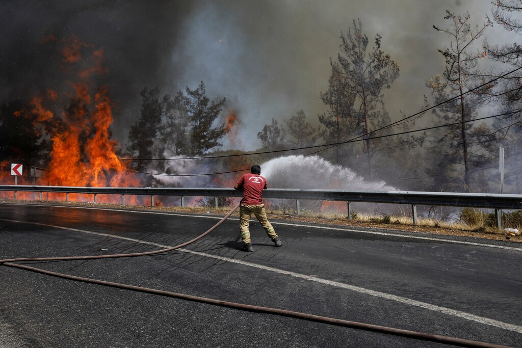 A firefighter tries to extinguish a wildfire near Marmaris, Turkey, August 1, 2021.