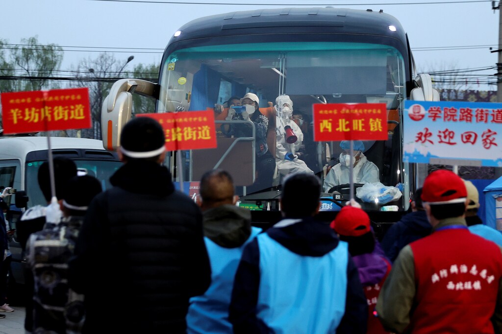 People returning from Hubei province, the epicentre of China's coronavirus disease (COVID-19) outbreak, arrive at an assembly point as workers of their communities wait to pick them up, in Beijing, China March 25, 2020. Picture taken March 25, 2020. cnsphoto via REUTERS. ATTENTION EDITORS - THIS IMAGE WAS PROVIDED BY A THIRD PARTY. CHINA OUT. - RC2GRF9LCDGI