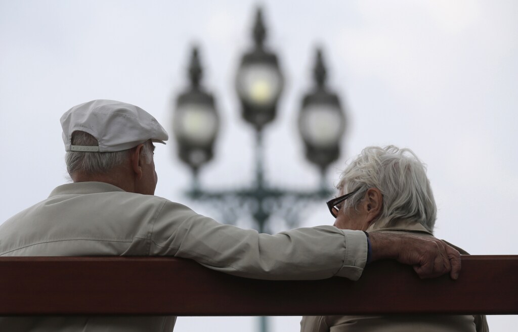 A retired couple sits on a bench in Enghien-les-Bains, north of Paris, August 26, 2013. France's government, which has been meeting with labour union heads about retirement issues, neared a deal with trade unions on Monday to overhaul the pension system via a slight lengthening of working lives, union chiefs said, as Europe's number two economy sought to bring a spiralling deficit under control. REUTERS/Christian Hartmann (FRANCE - Tags: POLITICS BUSINESS EMPLOYMENT) - RTX12X57
