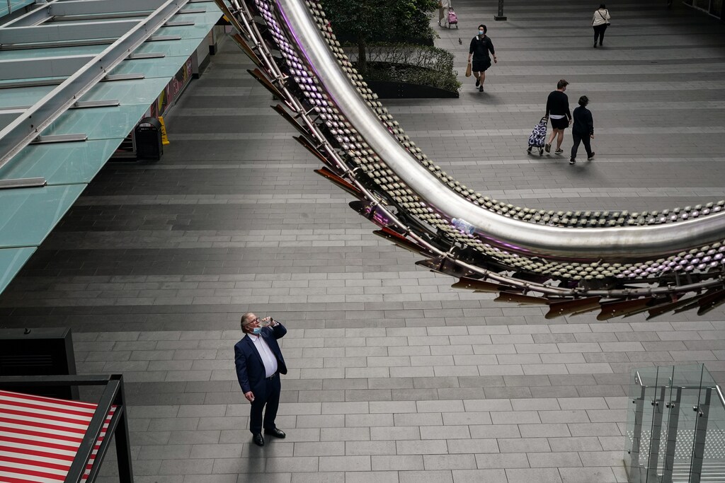 People pass through a quiet shopping mall plaza in the city centre during a lockdown to curb the spread of a coronavirus disease (COVID-19) outbreak in Sydney, Australia, September 28, 2021. REUTERS/Loren Elliott - RC2UYP948KIX