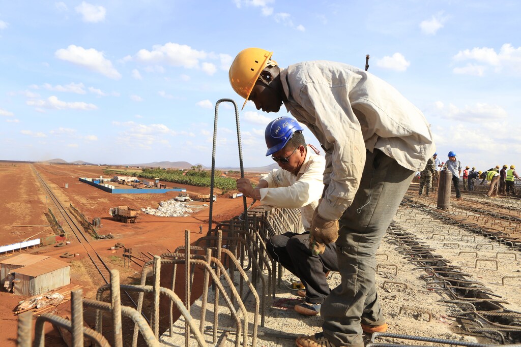 A Chinese engineer and a local construction worker work on a section of the Mombasa-Nairobi standard gauge railway (SGR) in Emali, Kenya October 10, 2015. The China Road and Bridge Corporation (CRBC) tasked with the construction work at a cost of 3.8 billion U.S. dollars is due for completion in mid-2017. REUTERS/Noor Khamis - D1AERZDORFAA