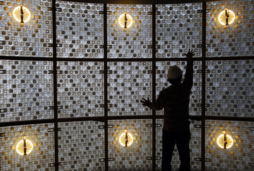 A construction worker touches up a wall made with plastic bottles inside the EcoArk building during a media preview in Taipei April 9, 2010. A Taiwan company has built a three-storey exhibition hall using 1.5 million plastic bottles instead of bricks to raise interest in recycling, creating what the builder described as a world-first. Picture taken April 9, 2010. REUTERS/Nicky Loh (TAIWAN - Tags: ENVIRONMENT SOCIETY) - RTR2CPOQ