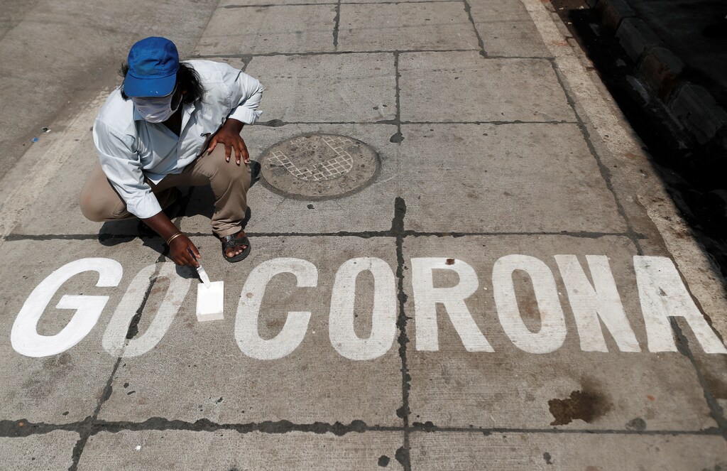 A man paints a message on a street after India ordered a 21- day nationwide lockdown to limit the spreading of coronavirus disease (COVID-19) in Mumbai, India March 28, 2020. REUTERS/Francis Mascarenhas TPX IMAGES OF THE DAY - RC2YSF9BHTFJ