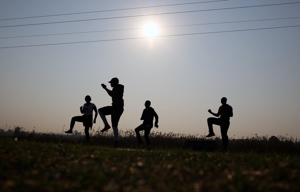 Locals take part in an exercise at a free outdoor gym in Soweto, South Africa September 22, 2017. REUTERS/Siphiwe Sibeko - RC1BC646E1C0