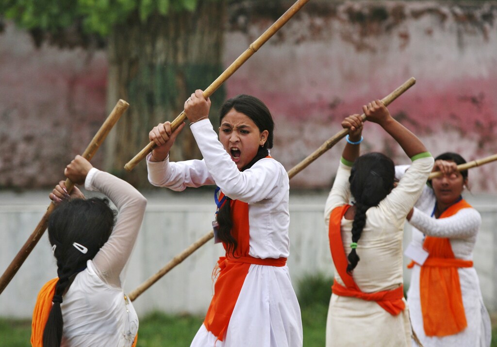 School girls wield bamboo sticks during an event held to demonstrate self-defence skills as part of a camp organized by the Vishwa Hindu Parishad (VHP), a Hindu group, in Jammu July 7, 2015. REUTERS/Mukesh Gupta - GF10000150967