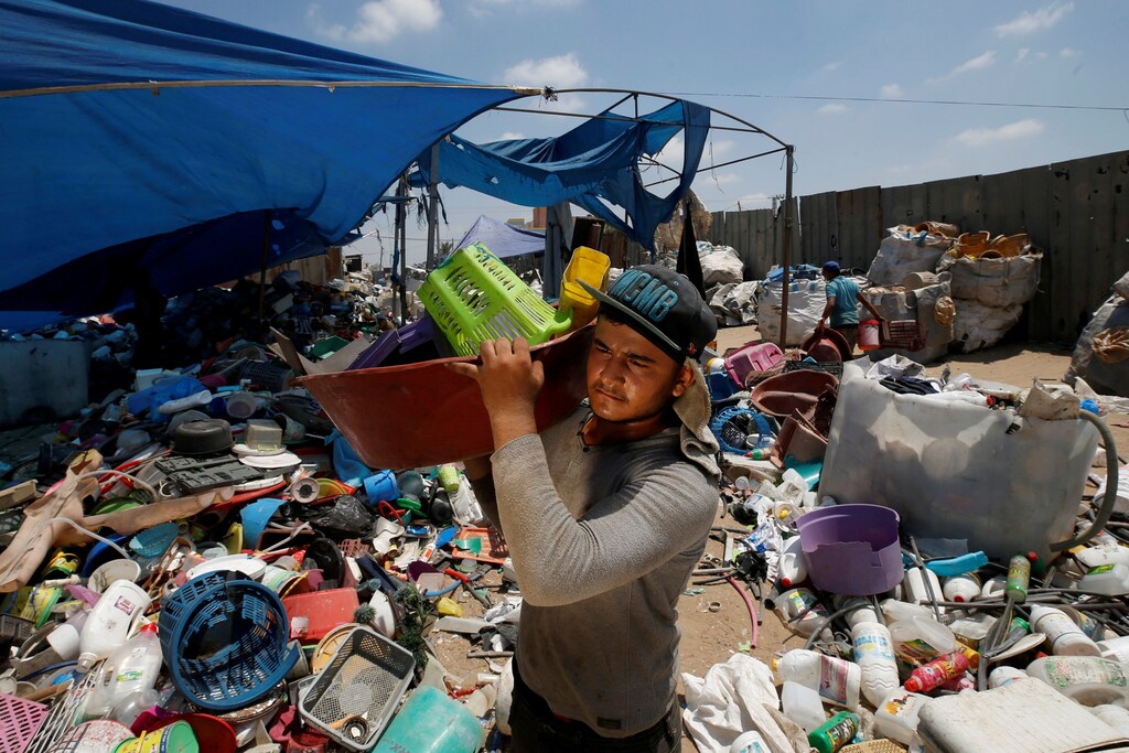 A Palestinian worker carries plastic items collected to be recycled in a factory in the northern Gaza Strip July 13, 2020. Picture taken July 13, 2020. REUTERS/Mohammed Salem TPX IMAGES OF THE DAY - RC29UH933MS5