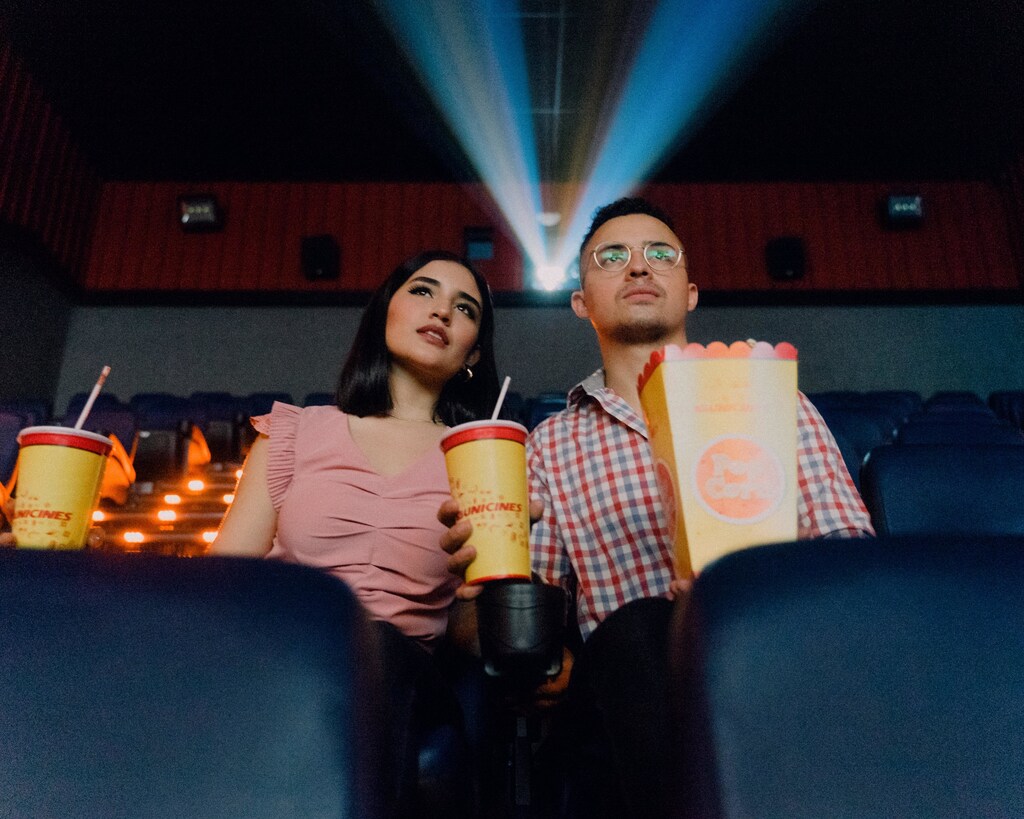 this couple are sitting in a cinema watching a film