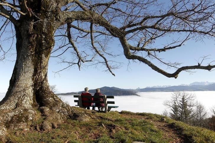 An elderly couple sits on a bench on the peak of Mount Hochwacht (988 metres/3241 ft) as high fog covers the landscape around the Swiss town of Zug November 20, 2012. Reuters/Arnd Wiegmann (SWITZERLAND - Tags: ENVIRONMENT)